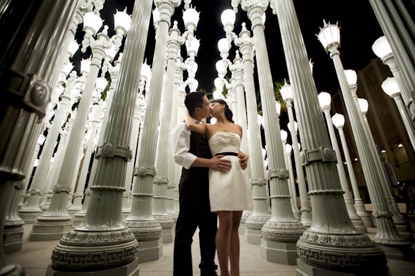 the happy couple kissing surrounded by light posts - wedding photo by top Orange County, California wedding photographers D. Park Photography